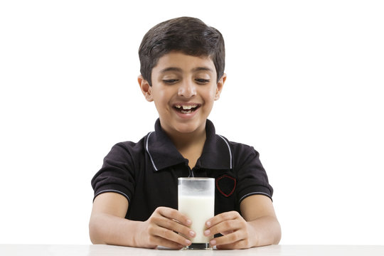 Young boy looking at a glass of milk 