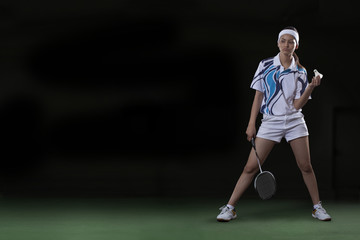 Obraz premium Full length of young woman with badminton racket and shuttlecock