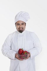 Portrait of chef with bowl of red capsicum