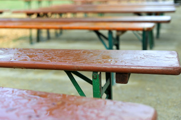 Leere Bänke im Sommer im Biergarten einer Gaststätte bei Regen / Featurebild „verregnet“ mit...