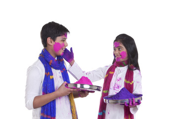 Girl putting holi colour on a boy