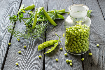 Green peas in jar and on branches in pods