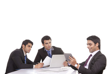 Businessman messaging as colleagues watch on