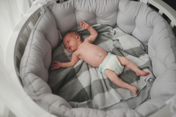 sweet newborn baby lying in big bed