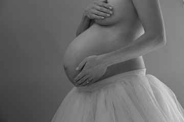 naked pregnant belly with wedding rings and tulle skirt in Black and white