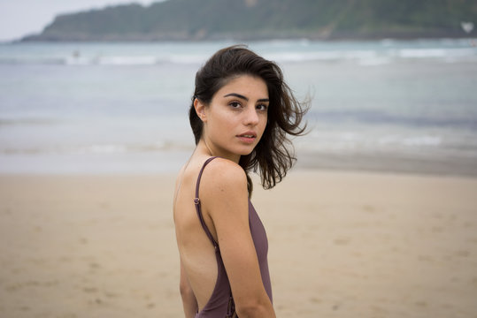 Portrait of beautiful woman in swimsuit standing on beach