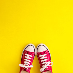 Vintage sneaker shoes in a flat lay composition over yellow background