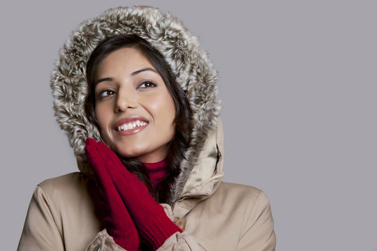 Happy young woman on winter clothes looking away 