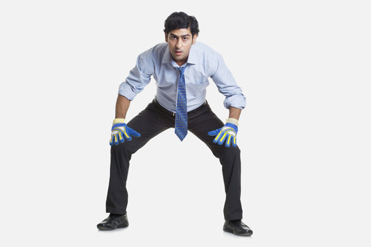 Business goalkeeper ready to save the goal over white background 