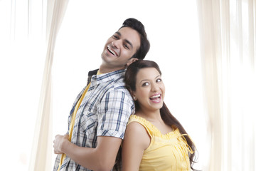 Obraz premium Young couple standing back to back