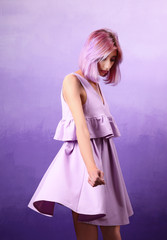 Beautiful young woman in dress on lilac background