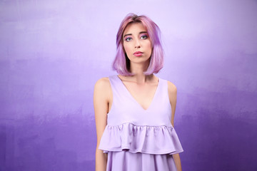 Beautiful young woman in dress on lilac background