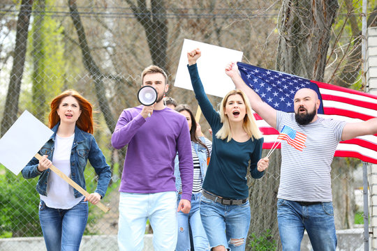 Group of protesting young people with American flag on street