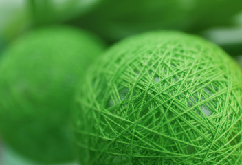 Green wicker ball on blurred background, closeup