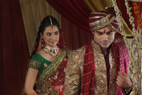 Smiling bride looking at man during mangal phera 
