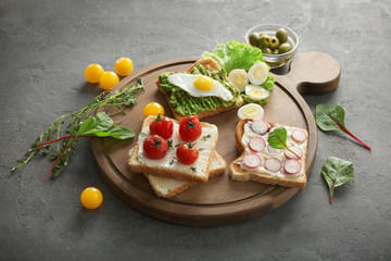 Different tasty breakfast toasts with vegetables on table