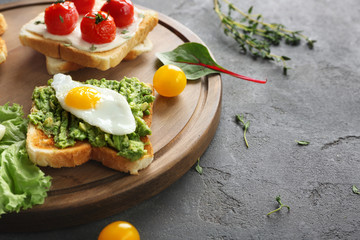Different tasty breakfast toasts with vegetables on table