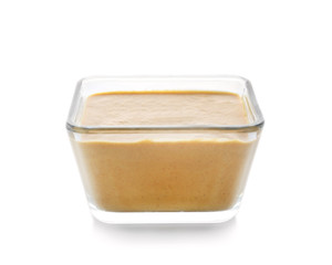 Bowl of delicious mustard sauce on white background