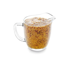 Glass jug of delicious Dijon mustard sauce on white background