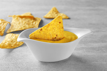 Gravy boat with delicious mustard sauce and nachos on table © Africa Studio