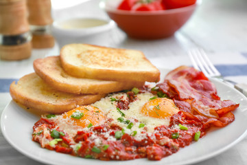 Plate with eggs in purgatory on table