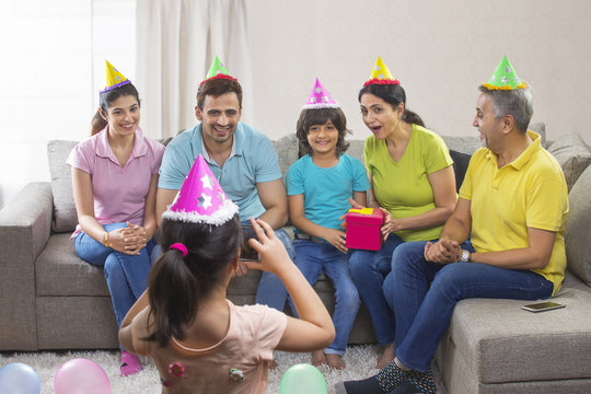 Little girl taking picture of family on birthday party