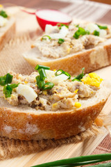 Closeup of crispy baguette with mackerel or tuna fish paste, healthy nutrition