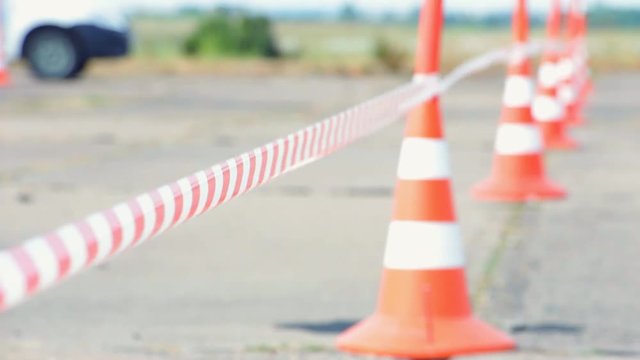 Selective focus. Fencing tape and road cone