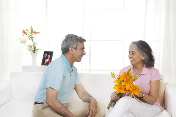 Husband giving flowers to his wife