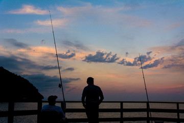 two men fishing during the sunset