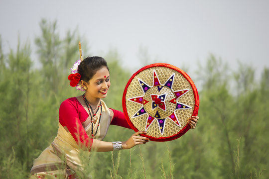 Bihu dancer holding a jaapi 