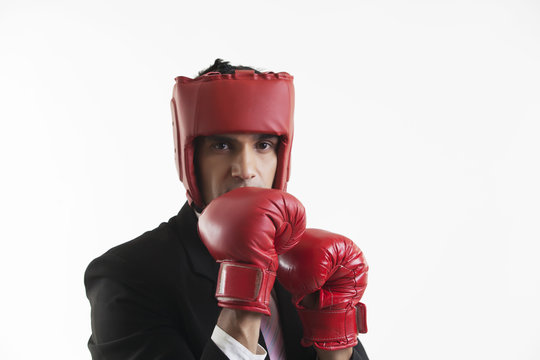 Businessman with boxing gloves in boxing stance 