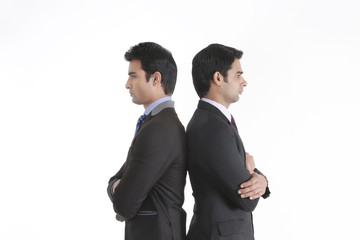 Two businessmen standing back to back