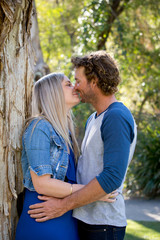 Young couple, man and woman standing closely together, about to kiss