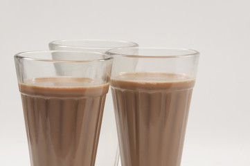 Close-up of chai glasses with an empty glass isolated over white background 