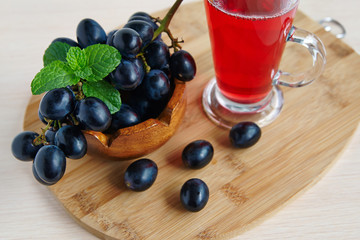A glass of juice and grapes
