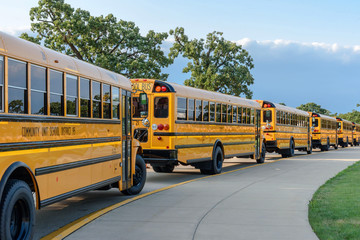 Fototapeta na wymiar school bus line in parking lot of high school