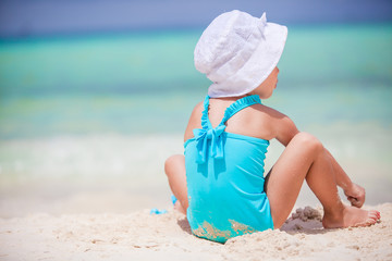 Fototapeta na wymiar Back view of little girl play on the beach