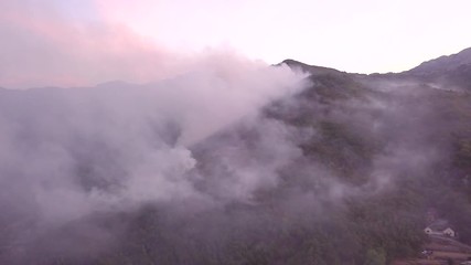 aerial view video 4K, summer fires in Europe forests 2017, 9th of august Montenegro Lovcen, aircraft extinguishes a fire, white smoke clouds, the trees are burning, aero video shooting