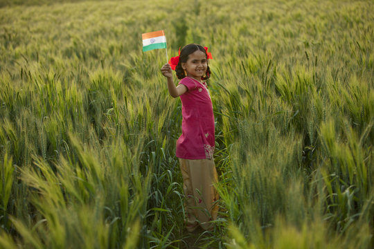 Portrait of a happy little girl holding an Indian flag 