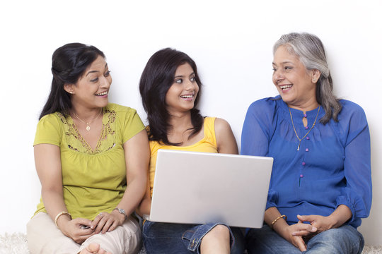Girl sitting with her mother and grandmother shopping online 