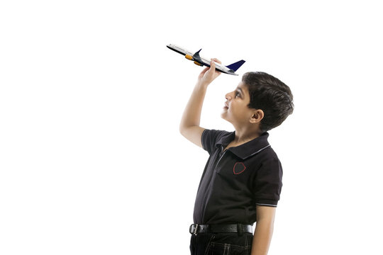 Young boy holding a model of a plane 