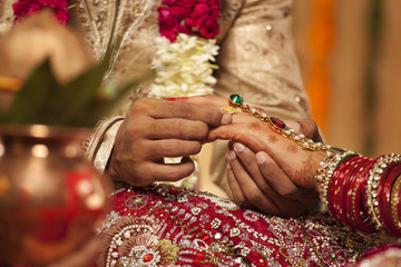 Fototapeta na wymiar Close-up of a groom putting a wedding ring on a bride 