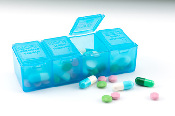 tiny pills, capsules and open pill box 