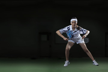 Fototapeta na wymiar Full length of young woman playing badminton