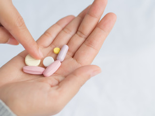 Closeup woman hand holding a pill. Healthcare, medical supplements concept