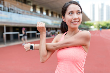 Sport woman stretching arm in sport stadium