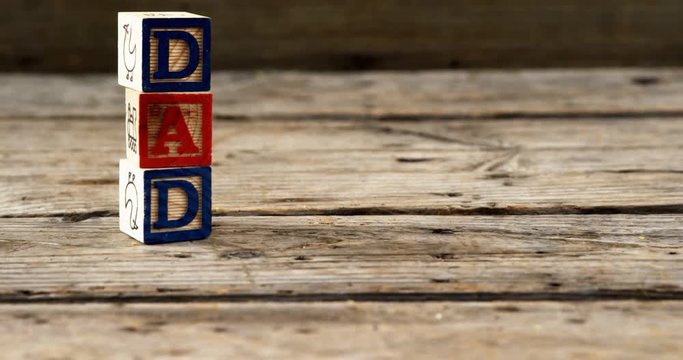 Blocks with text dad on wooden plank