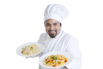 Portrait of chef holding plates with pasta