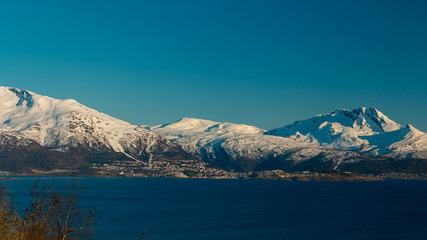 Fototapeta na wymiar Narvik seen from distance with mountains and blue sky